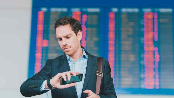 uomo che guarda orologio in aeroporto