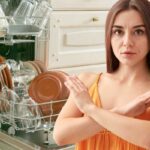 piatti in lavastoviglie aperta e donna braccia incrociate