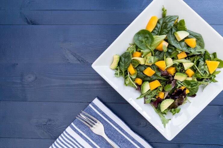 Piatto con insalata con spinaci, mango, avocado